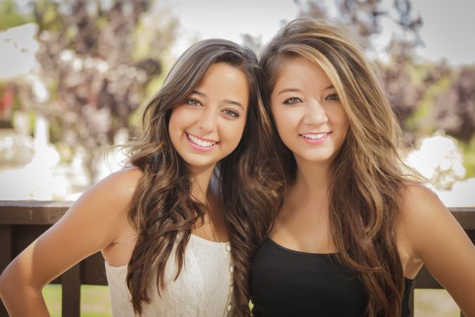Two female friends posing in outside garden