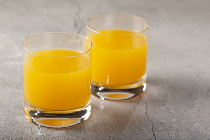 Glass with orange juice on the table.