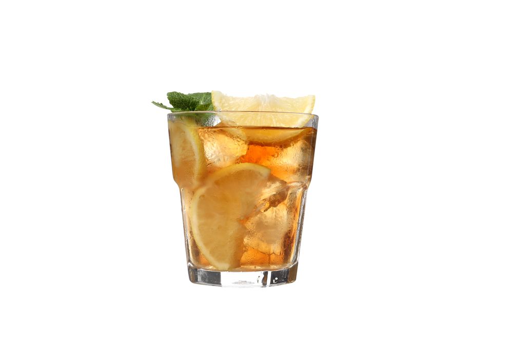 A glass of cold tea with an orange, isolated on plain background