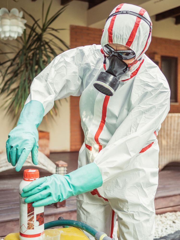 Man in suit for fumigation pouring chemical into tank