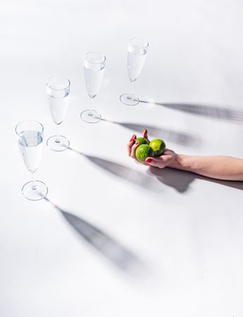 Composition of a hand with citrus and glasses of water
