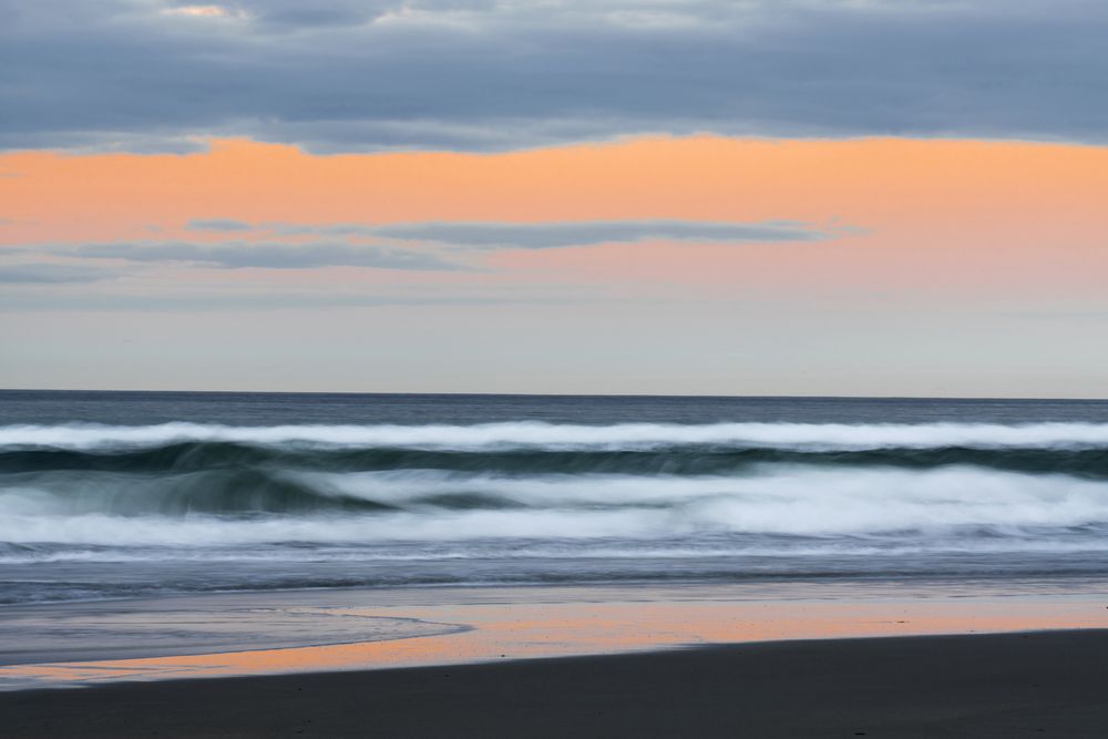 Idyllic seashore with rough waves in sunset