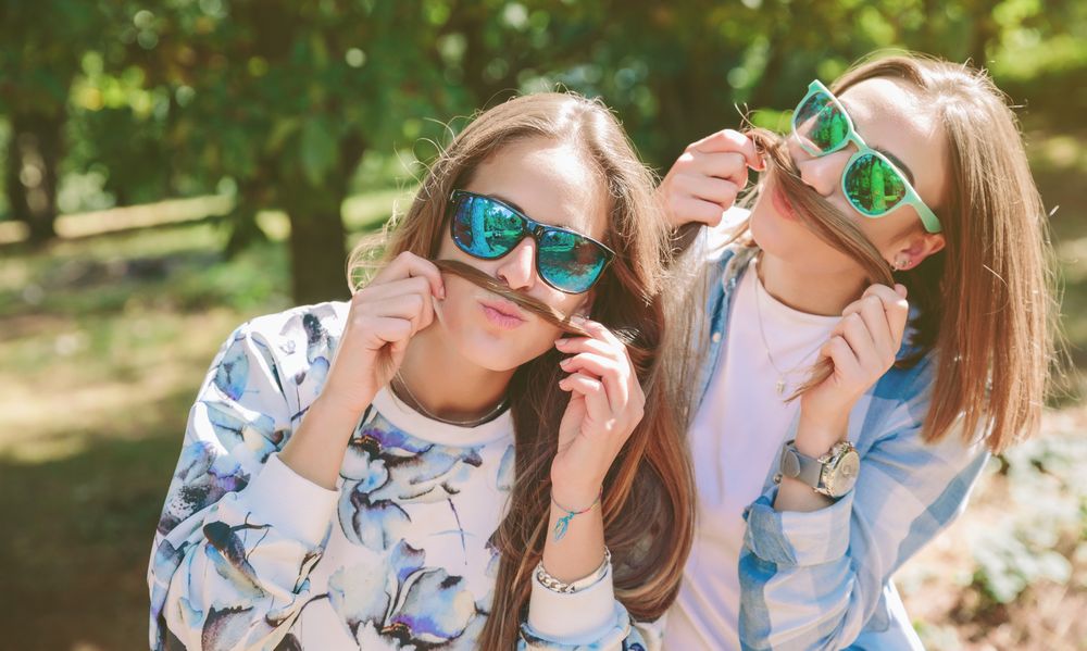 Women having fun doing moustaches with hair