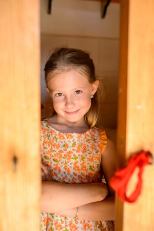Smiling girl with crossed arms in floral sundress