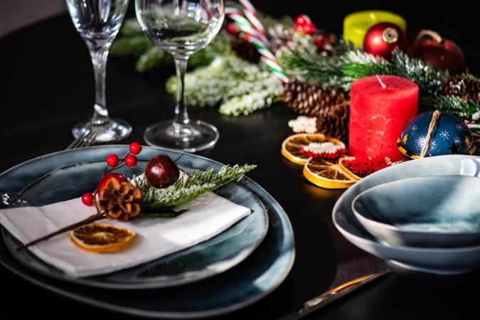 Christmas table setting with navy plate and seasonal branch