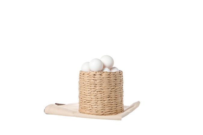 eggs in a round basket, isolated on blank background.