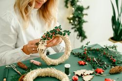Woman decorating Christmas wreath at home