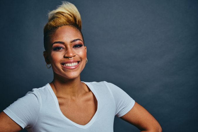 Smiling Black woman with short blonde hair with hands on her hips