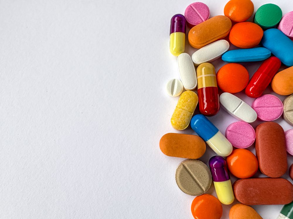 Colorful Capsules and Tablets on Plain Background with Copy Space