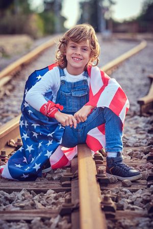 Delightful child rejoicing American Independence Day on rails