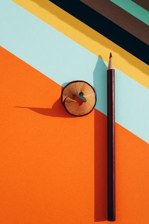 Pencil and shavings from sharpening, on colored striped papers
