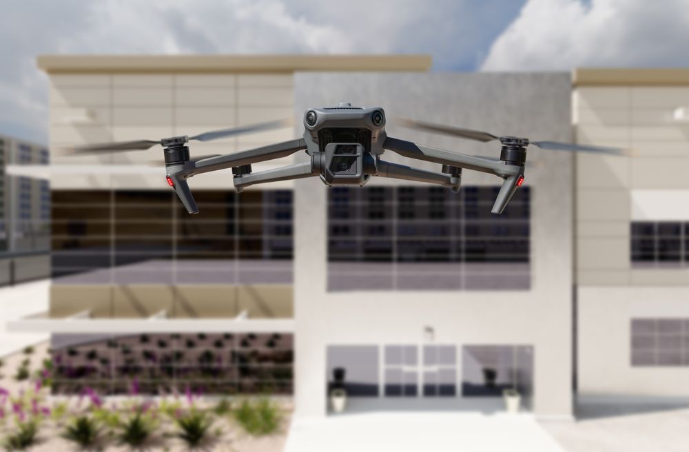 Unmanned Aircraft System Quadcopter Drone UAV In The Air Near Corporate Industrial Building