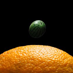 Space scene with orange and watermelon in place of the earth and moon
