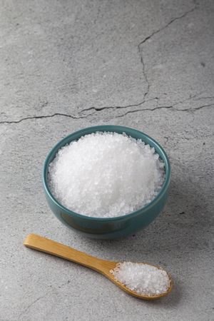 Bowl with coarse salt on the table.