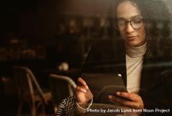 Businesswoman sitting at a cafe using digital tablet 0PzKm4