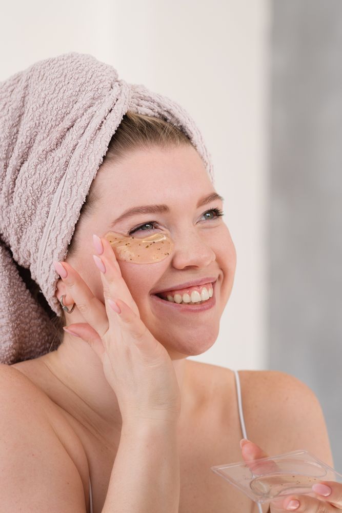 Applying eye patches in skincare routine.