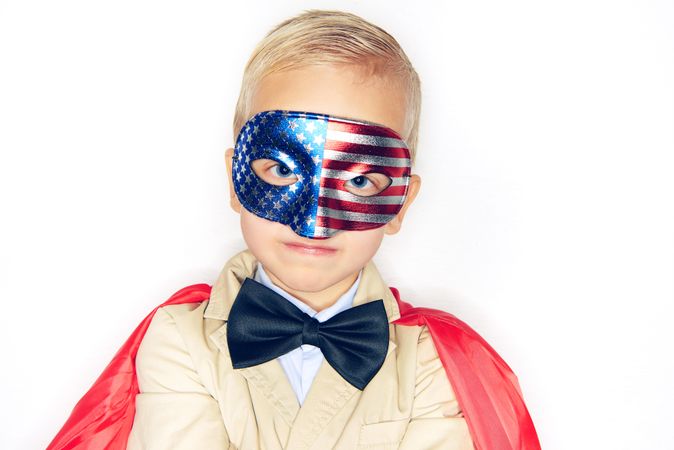 Serious blond boy wearing American flag mask