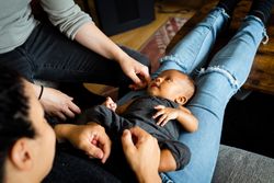 Cute new born baby lying back on mother’s lap