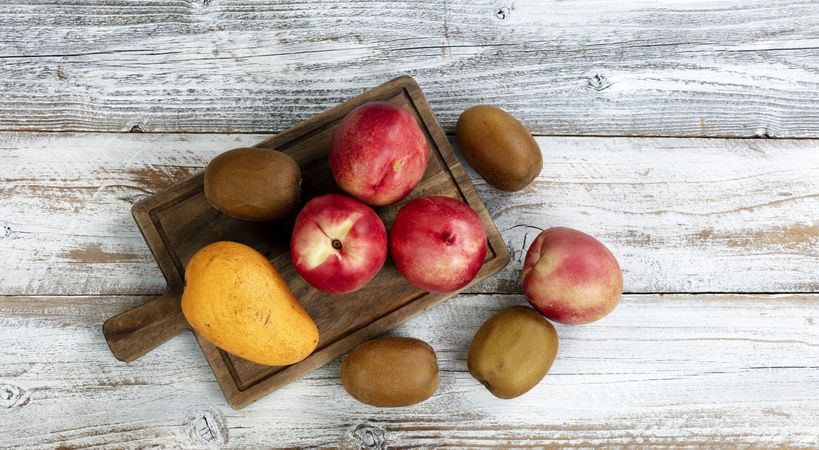 Rustic table setting consisting of peach, kiwi, and mango