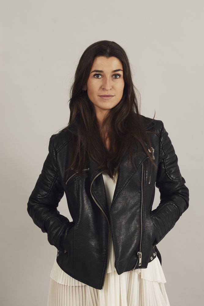 Serious pensive young female wearing leather jacket in studio