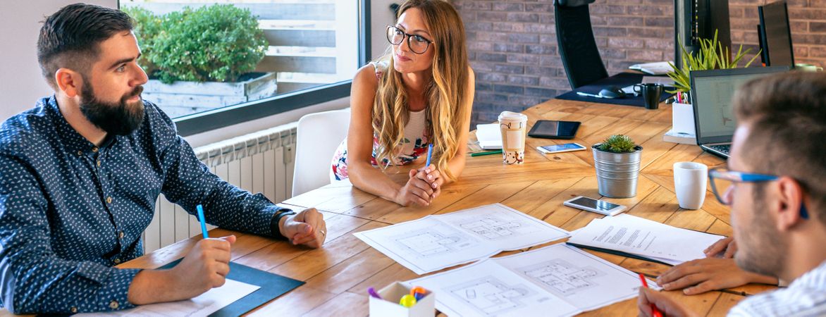 Businesspeople in a work meeting looking at construction drawing