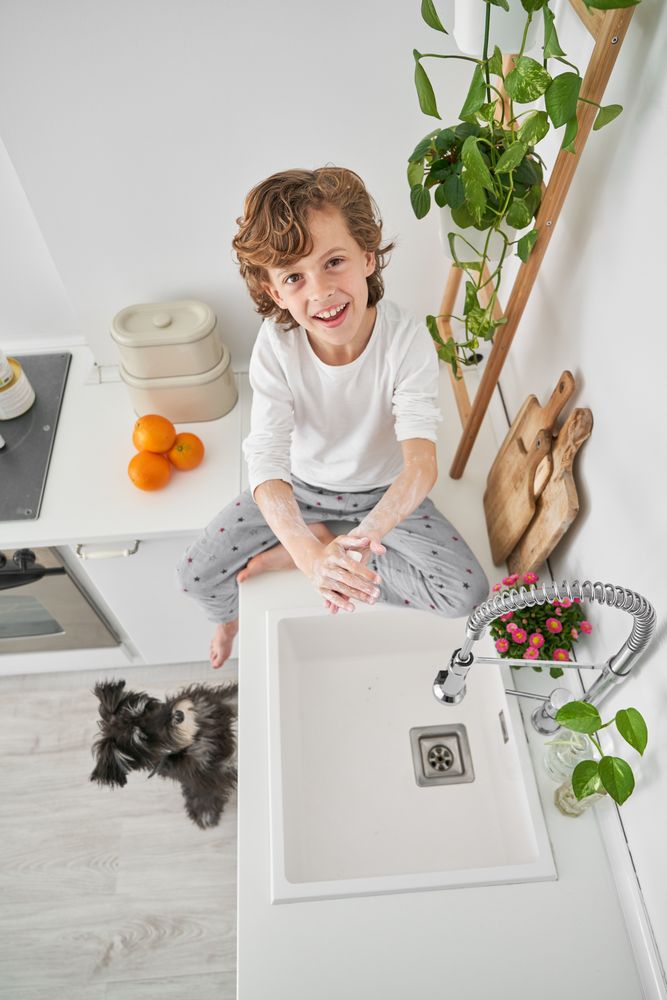 Smiling boy doing hygiene routine in kitchen