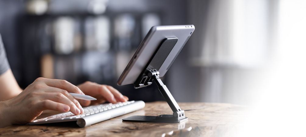 Man working on tablet with keyboard
