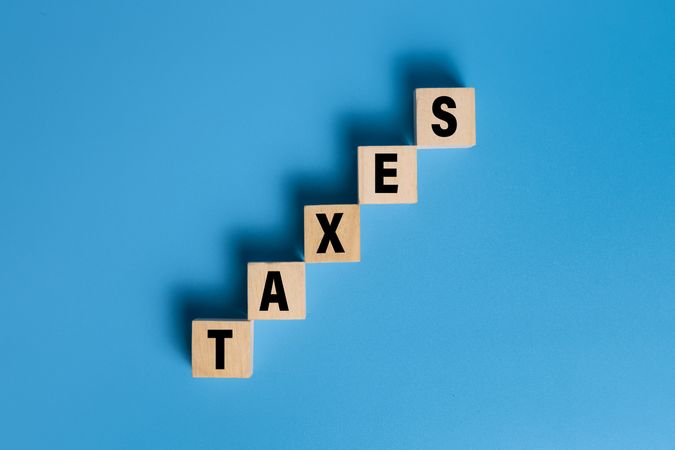 taxes word text on wooden blocks isolated on blue background