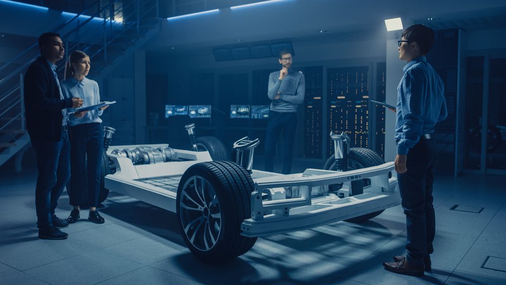 Automobile Engineers Designing Electric Car Platform Chassis Prototype, Using Tablet Computers with CAD Software