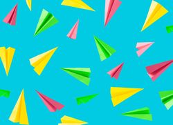 Colorful background pattern made with paper airplanes on sky blue background