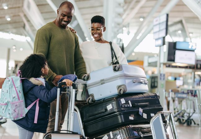 Black family of three at airport terminal waiting for flight