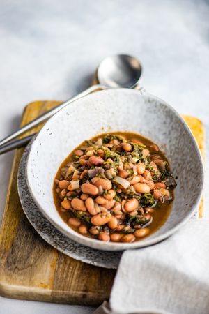 Traditional Georgian bean dish - lobio, served in modern textured ceramic bowl on wooden board