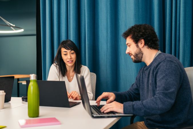 Coworkers in a company meeting analyzing company data. They are in a meeting room of a modern coworking office space