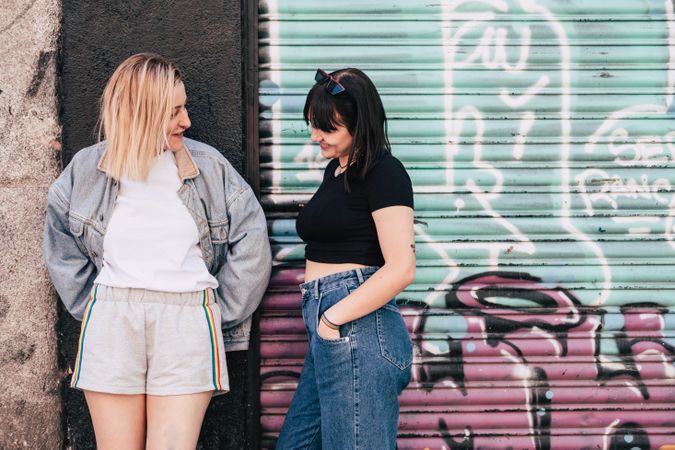 Lesbian couple leaning in a wall on street