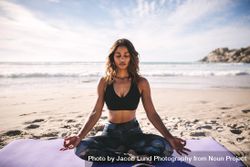Healthy woman doing yoga asana meditation on the beach 4dGdN5