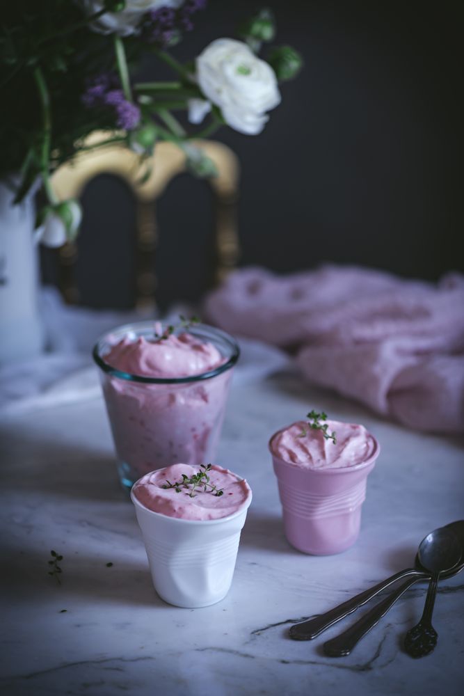 tasty glasses of strawberry mousse on a table with flowers