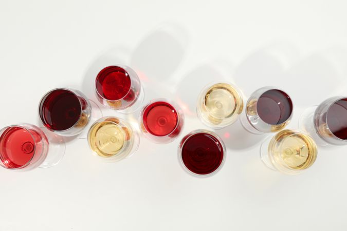 Flat lay composition. Glasses with different wine on blank background, top view