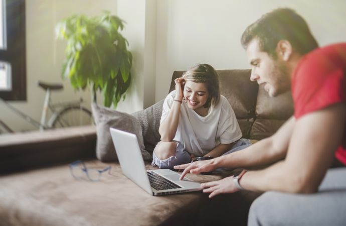 Couple browsing laptop on couch