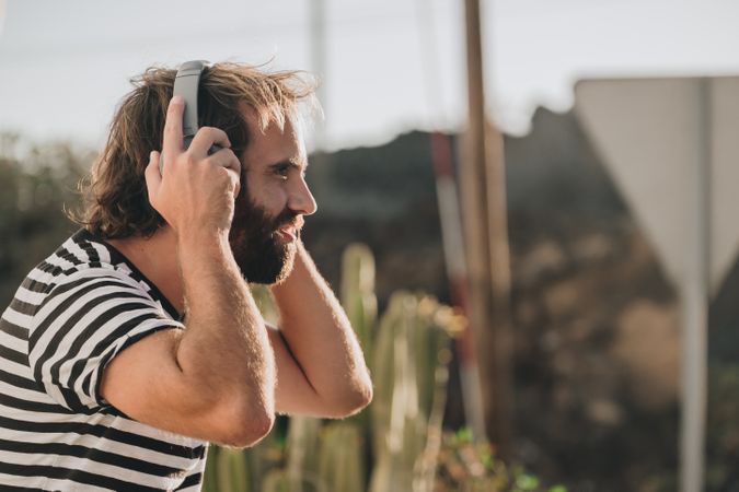 Young male sitting with smartphone and headphones