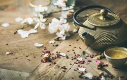 Oriental teapot with teacups and dried flowers