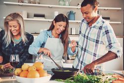 Multi-ethnic group of people cooking asparagus in a bright kitchen