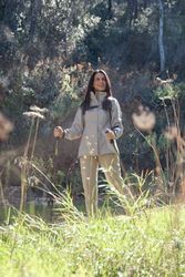 Hispanic woman with walking poles in nature
