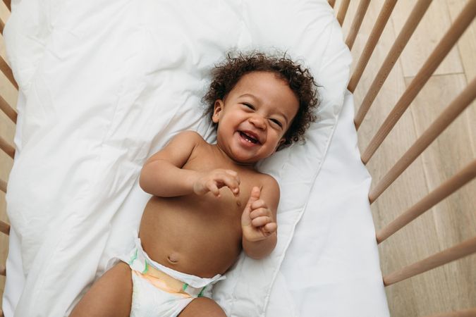 Cute and happy baby boy in his crib