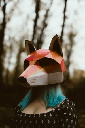 Woman in red fox mask walking in forest