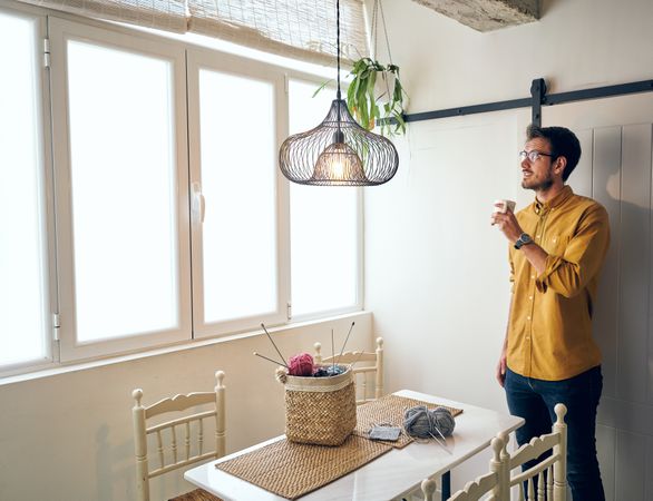 Man drinking hot tea during knitting