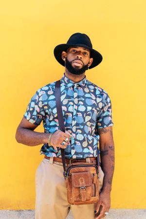 Stylish Black man outdoors over yellow background