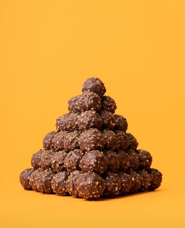 Chocolate truffle pyramid on an orange background