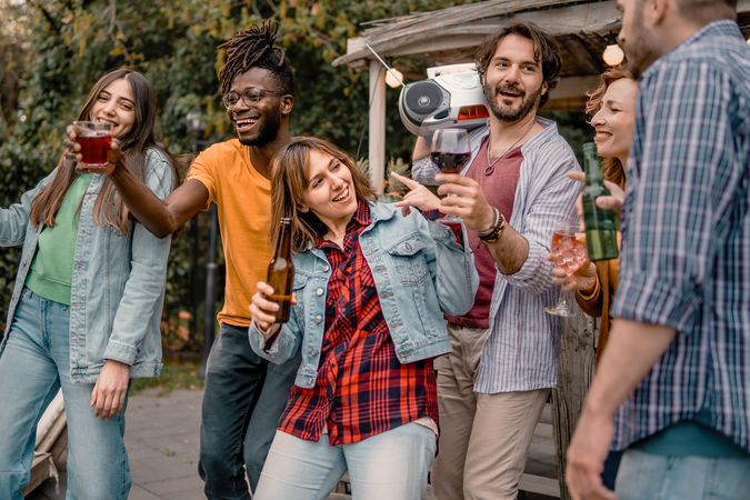 A diverse group of adults toasts to friendship at an outdoor gathering