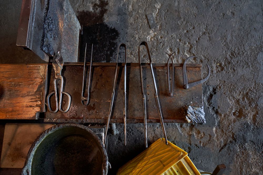 Metal tools on workbench in glass making factory