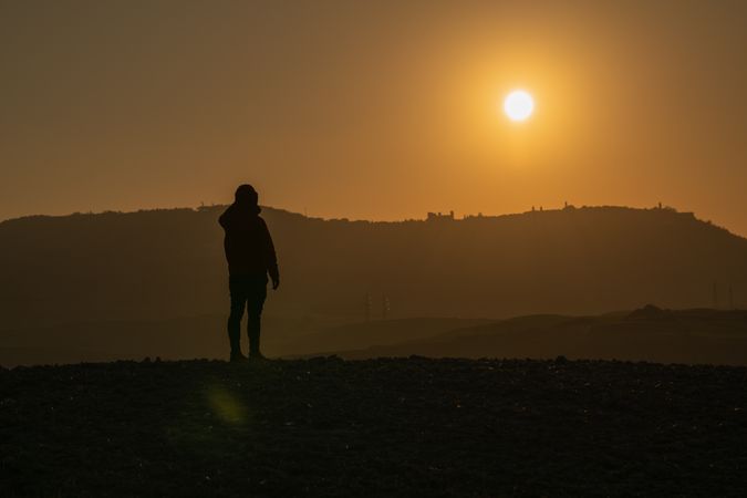 Traveler on field in sunset light
